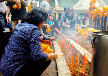 Lighting incense at the site of the recent Bangkok bombings.